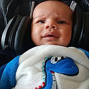 élio a rejoint le concours — aidez-le/la à gagner de superbes lots ! baby, headphones, blanket, dinosaur, blue, white, person, child, clothing, face, indoor, expression, cute, cozy, hoodie, adult, portrait, closeup, infant, soft