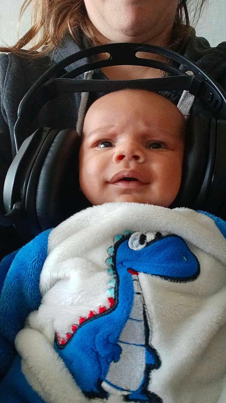 élio a rejoint le concours — aidez-le/la à gagner de superbes lots ! baby, headphones, blanket, dinosaur, blue, white, person, child, clothing, face, indoor, expression, cute, cozy, hoodie, adult, portrait, closeup, infant, soft