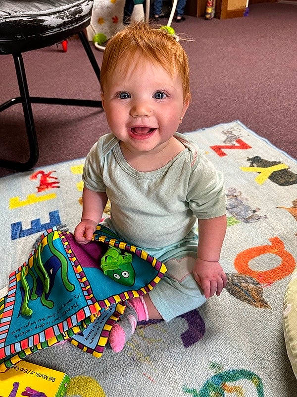 Savanna is registered to the contest to win money with this photo: baby, baby_toddler_clothing, baby_toys, cheek, child, event, flooring, fun, happy, holiday, joy, linens, pattern, person, play, room, sitting, smile, t_shirt, table
