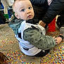 Elyo a rejoint le concours — aidez-le/la à gagner de superbes lots ! casual_clothing, celebration, child, colorful, confetti, costume, curious, event, floor, hoodie, indoor, legs, party, pattern, people, portrait, shoes, sitting, toddler, young_child