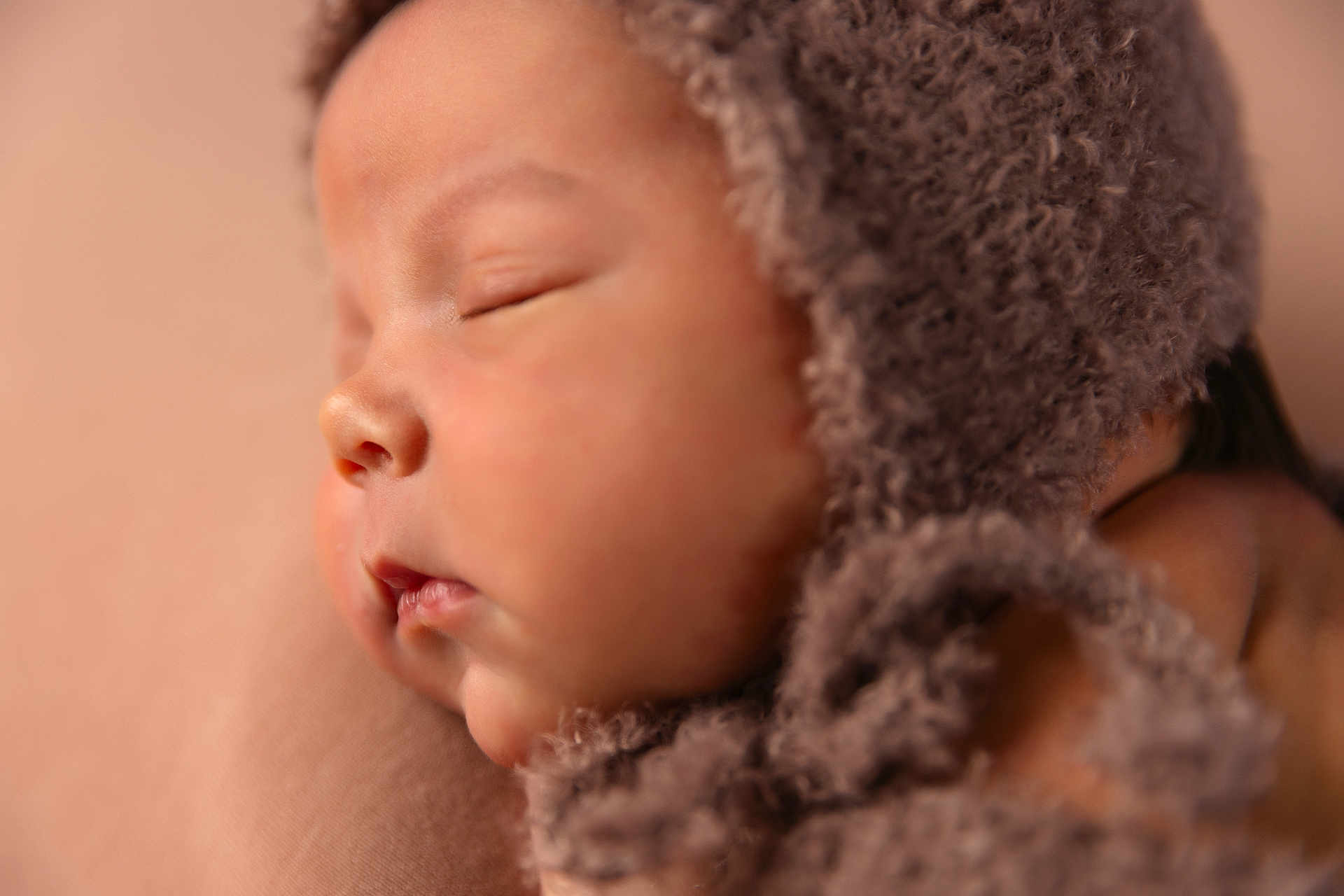 Nathan is registered to the contest to win money with this photo: baby, sleeping, closeup, face, infant, bonnet, soft_focus, peaceful, newborn, skin, headwear, portrait, warm_tones, cozy, cute, child, resting, soft_texture, indoors, calm