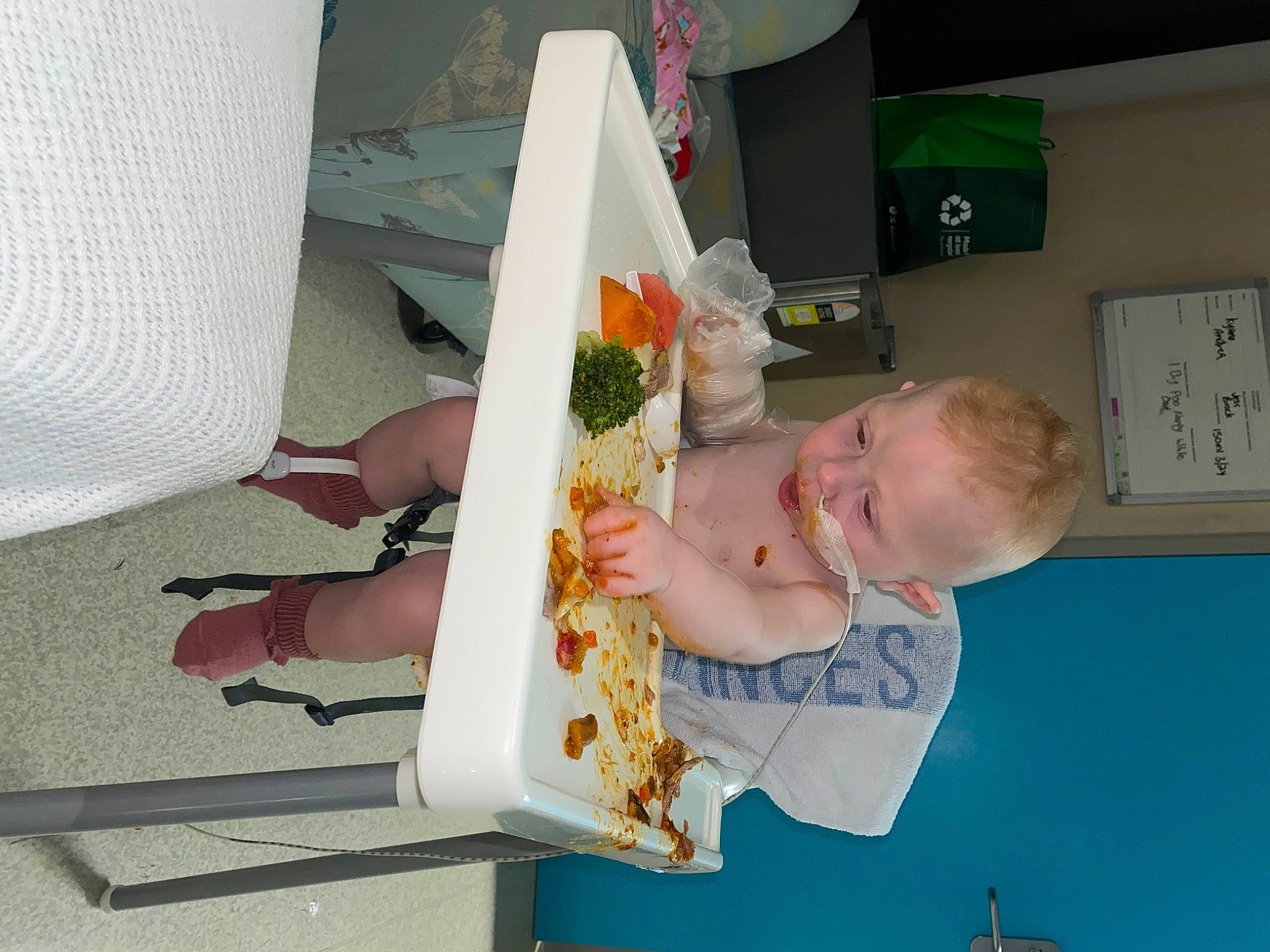 Marley is registered to the contest to win money with this photo: baby, baby_food, child, cut_flowers, floral_design, flower, flower_arranging, human_leg, person, plant_milk, room, sandal, sitting, thigh, toddler