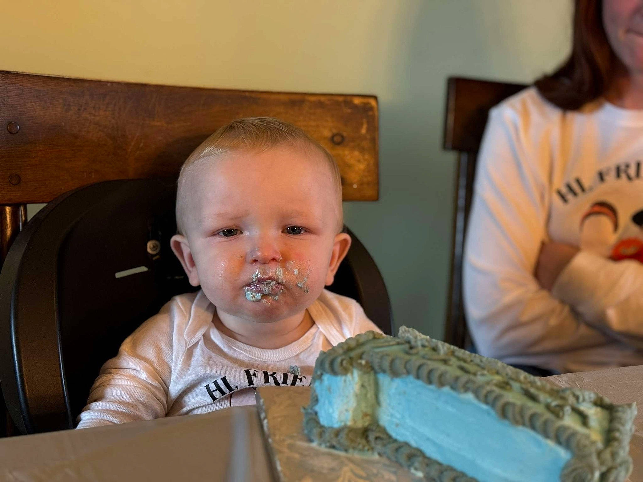 Grayson is registered to the contest to win money with this photo: baby, baby_toddler_clothing, birthday_cake, cake, cake_decorating, chair, cheek, child, event, face, food, fun, head, iris, person, plate, sharing, sitting, t_shirt, tableware