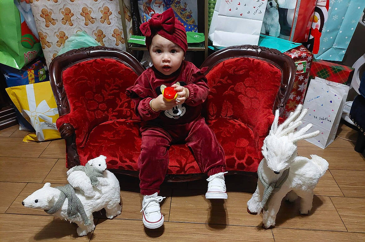 Jazelle is registered to the contest to win money with this photo: baby, chair, child, christmas_ornament, couch, event, flooring, fun, fur, fur_clothing, green, headwear, holiday, lap, leisure, living_room, person, santa_claus, sitting, stuffed_toy