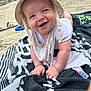 Jules participe au concours pour gagner de l'argent avec cette photo : baby, smiling, hat, bib, towel, sand, beach, happy, child, crawling, sun_hat, outdoor, clothing, infant, person, summer, playful, cute, skin, expression