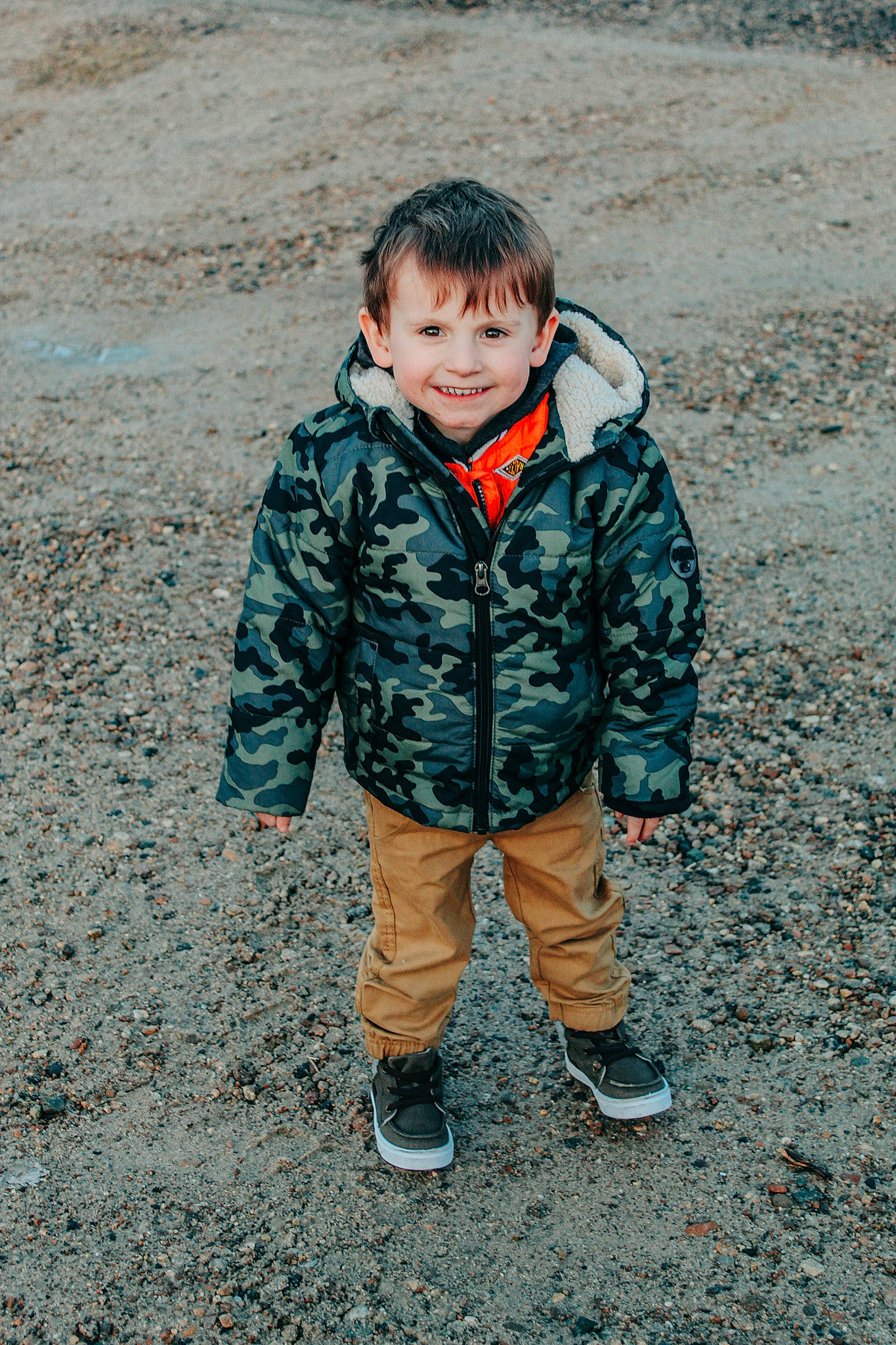 Atlas is registered to the contest to win money with this photo: asphalt, denim, eye, footwear, freezing, grass, happy, jacket, joy, military_camouflage, pattern, people_in_nature, person, road_surface, shoe, sleeve, smile, soil, street_fashion, toddler