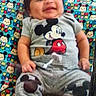 baby, smiling, mickey_mouse, infant, clothing, cushion, colorful, pattern, cute, happy, child, sitting, indoors, portrait, person, playful, cartoon, fabric, feet, sock