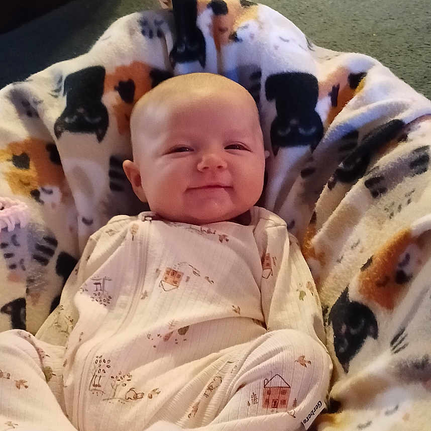 Margaret Hamilton joined the competition — help win amazing prizes! animal_print, baby, blanket, boots, carpet, child, clothing, comfort, cozy, cute, floor, happy, home, indoors, infant, portrait, seated, shoes, smiling, warm