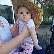 Margaret Hamilton joined the competition — help win amazing prizes! baby, infant, straw_hat, onesie, strawberry_pants, pink_sock, adult_hand, lap, wooden_deck, stroller, window, house_exterior, trees, outdoors, blue_eyes, person, holding, neutral_expression, cute, porch_railing