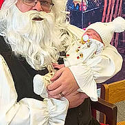 Margaret Hamilton is registered to the contest to win money with this photo: baby, santa_claus, beard, glasses, hat, pacifier, book, chair, indoor, holiday, christmas, child, person, clothing, costume, festive, smile, warm, holding, sleeping