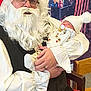 baby, santa_claus, beard, glasses, hat, pacifier, book, chair, indoor, holiday, christmas, child, person, clothing, costume, festive, smile, warm, holding, sleeping