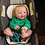 Margaret Hamilton is registered to the contest to win money with this photo: baby, infant, car_seat, onesie, green_clothing, smile, red_hair, teether, toy, bare_feet, hands, pillow, blanket, patterned_rug, floor, indoors, portrait, cheeks, happy, seat_buckle