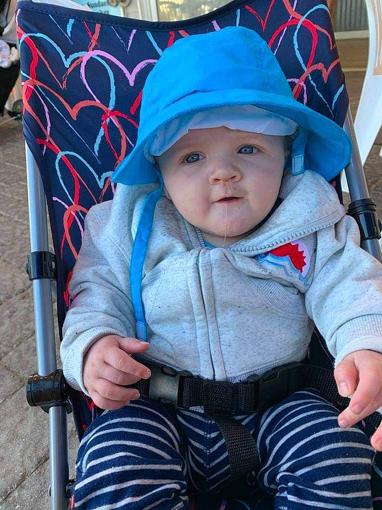 Jesiah is registered to the contest to win money with this photo: baby, baby_carriage, baby_products, baby_toddler_clothing, black, cap, cheek, child, electric_blue, eye, fun, grass, headwear, person, product, recreation, sitting, skin, sleeve, toddler