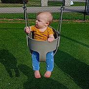 Amarah joined the competition — help win amazing prizes! baby, child, swing, playground, outdoor, grass, fence, park, daylight, curious, infant, casual_clothing, barefoot, greenery, trees, sunlight, seat, play, baby_clothes, blue_pants