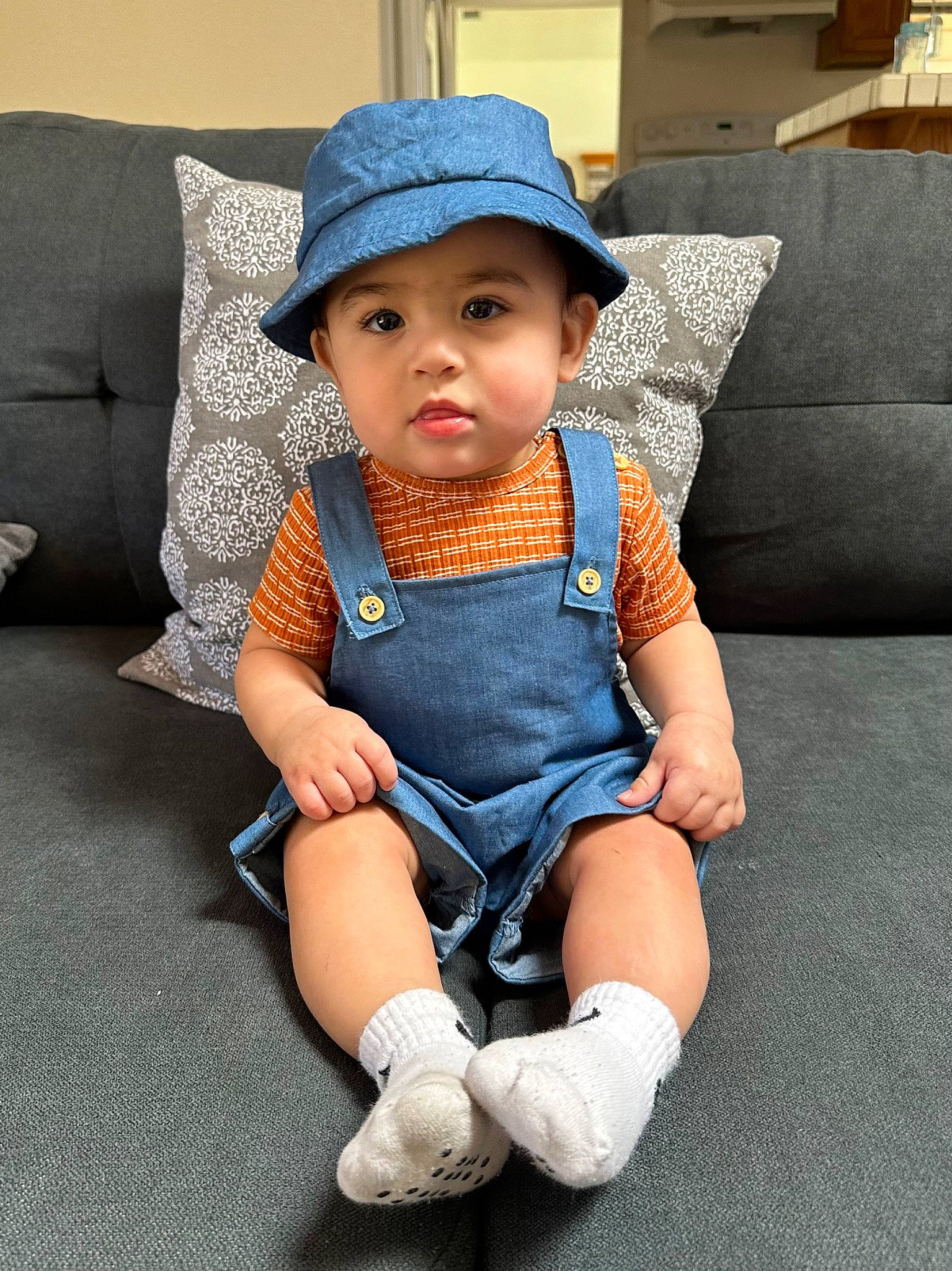 Emilio joined the competition — help win amazing prizes! baby, baby_products, baby_toddler_clothing, child, comfort, couch, electric_blue, eye, face, fashion_accessory, fun, hat, headwear, iris, pattern, person, sitting, sleeve, sock, sun_hat
