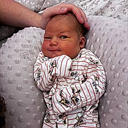 Alana is registered to the contest to win money with this photo: newborn, baby, infant, hand, blanket, onesie, striped_clothing, cartoon_print, soft_texture, resting, cute, sleepy, comfort, gentle_touch, person, indoors, closeup, skin, head, portrait