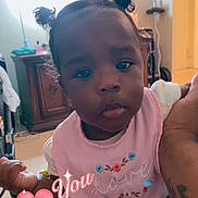 Ryleigh joined the competition — help win amazing prizes! baby, infant, child, pink_bib, hair_puffs, indoor, person, cute, love, embroidery, hand, furniture, room, lighting, tattoo, floor, cabinet, curious, portrait, holding