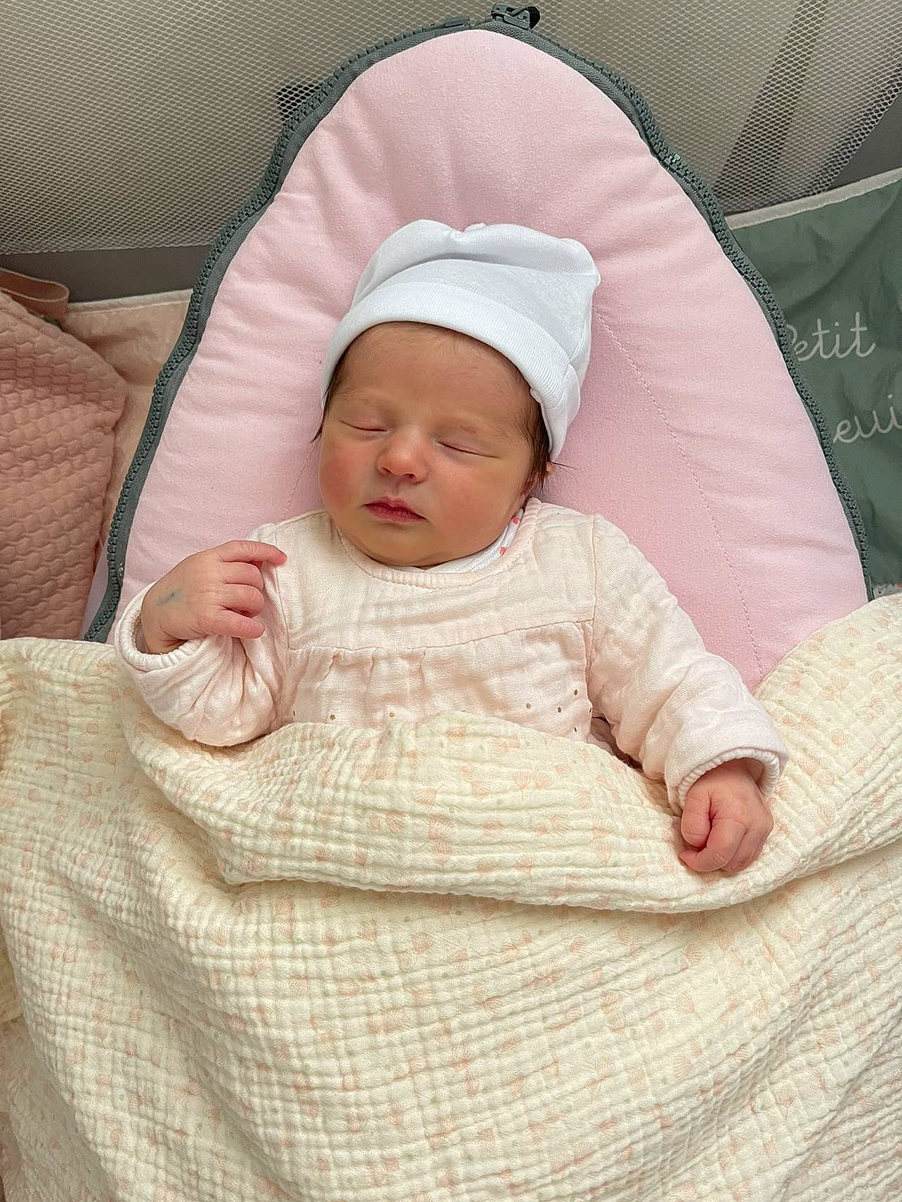 Maï-linh participe au concours pour gagner de l'argent avec cette photo : baby, baby_products, baby_safety, baby_sleeping, baby_toddler_clothing, bedding, beige, cheek, child, chin, comfort, eye, face, headwear, linens, peach, person, product, sleeve, textile