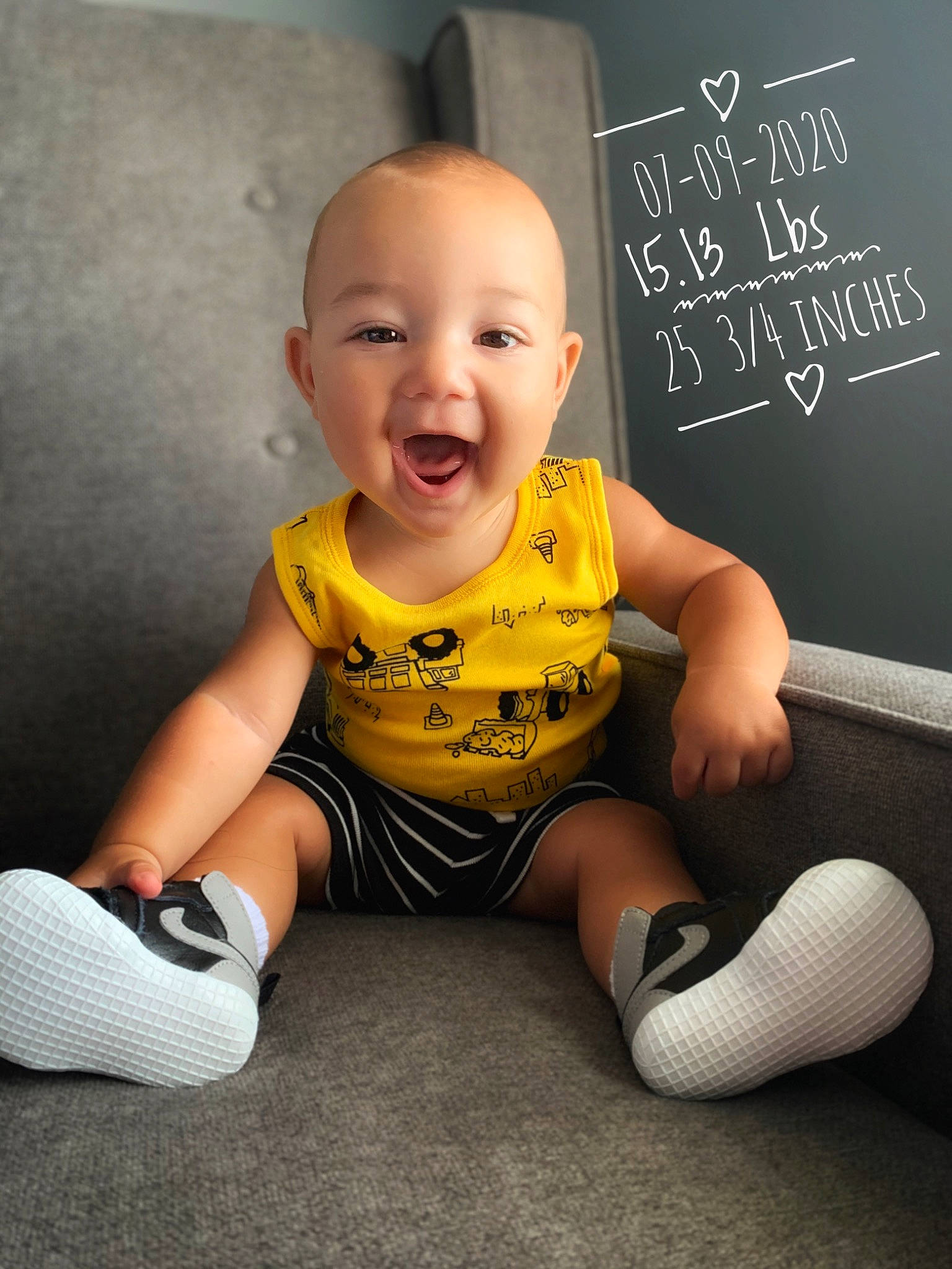 Hudson is registered to the contest to win money with this photo: arm, baby, baby_toddler_clothing, child, cool, facial_expression, footwear, happy, person, photo_caption, photography, play, product, shoe, sitting, sleeve, smile, t_shirt, toddler, yellow
