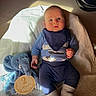 baby, infant, blue_clothing, plush_elephant, wooden_sign, 2_months, blanket, sock, laying_down, indoor, carpet, child, cute, portrait, soft_toys, sunlight, warm_lighting, baby_bib, hands, face