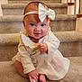 Lucy is registered to the contest to win money with this photo: baby, child, stairs, carpet, headband, bow, dress, smile, cute, infant, sitting, indoors, foot, hand, person, happy, young, portrait, apparel, cozy