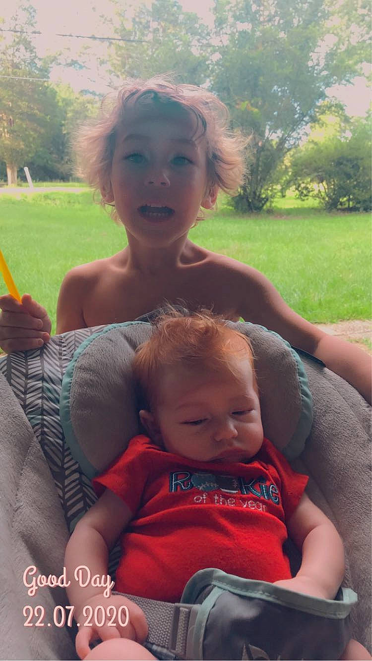 Dillon is registered to the contest to win money with this photo: arm, baby, face, facial_expression, fun, grass, hairstyle, happy, lap, leisure, people, people_in_nature, person, photograph, plant, product, skin, summer, sunlight, toddler