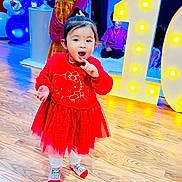 Aratrika joined the competition — help win amazing prizes! toddler, child, red_dress, hello_kitty, balloons, birthday, number_one, party, floor, wooden_floor, celebration, indoor, lighting, person, socks, cute, decorations, smiling, people, event