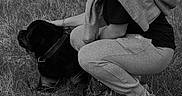 Paco participe au concours pour gagner de l'argent avec cette photo : woman, dog, grass, outdoor, pet, crouching, casual_clothing, black_and_white, nature, animal, companion, leash, hairstyle, relaxed, friendship, field, daytime, person, sweatpants, sweatshirt
