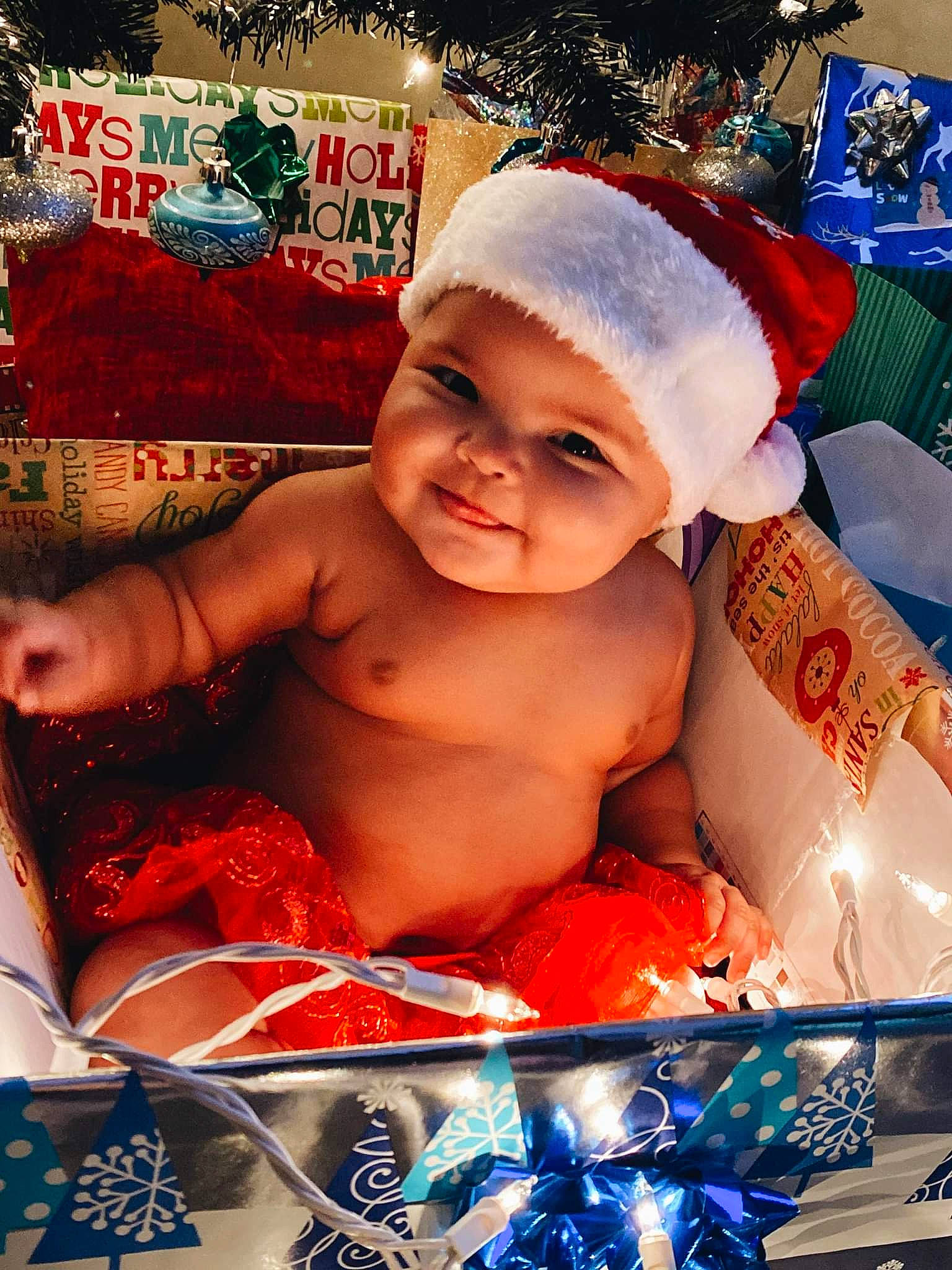 Stevie is registered to the contest to win money with this photo: baby, blue, child, christmas_eve, christmas_ornament, event, fictional_character, fun, happy, headwear, holiday, human_body, joy, laugh, leisure, pattern, person, santa_claus, smile, sweetness