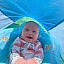 baby, smiling, water, pool_float, sunshade, swimsuit, infant, outdoor, summer, happy, child, blue, inflatable, sitting, playful, water_toy, cute, sunlight, recreation, joy