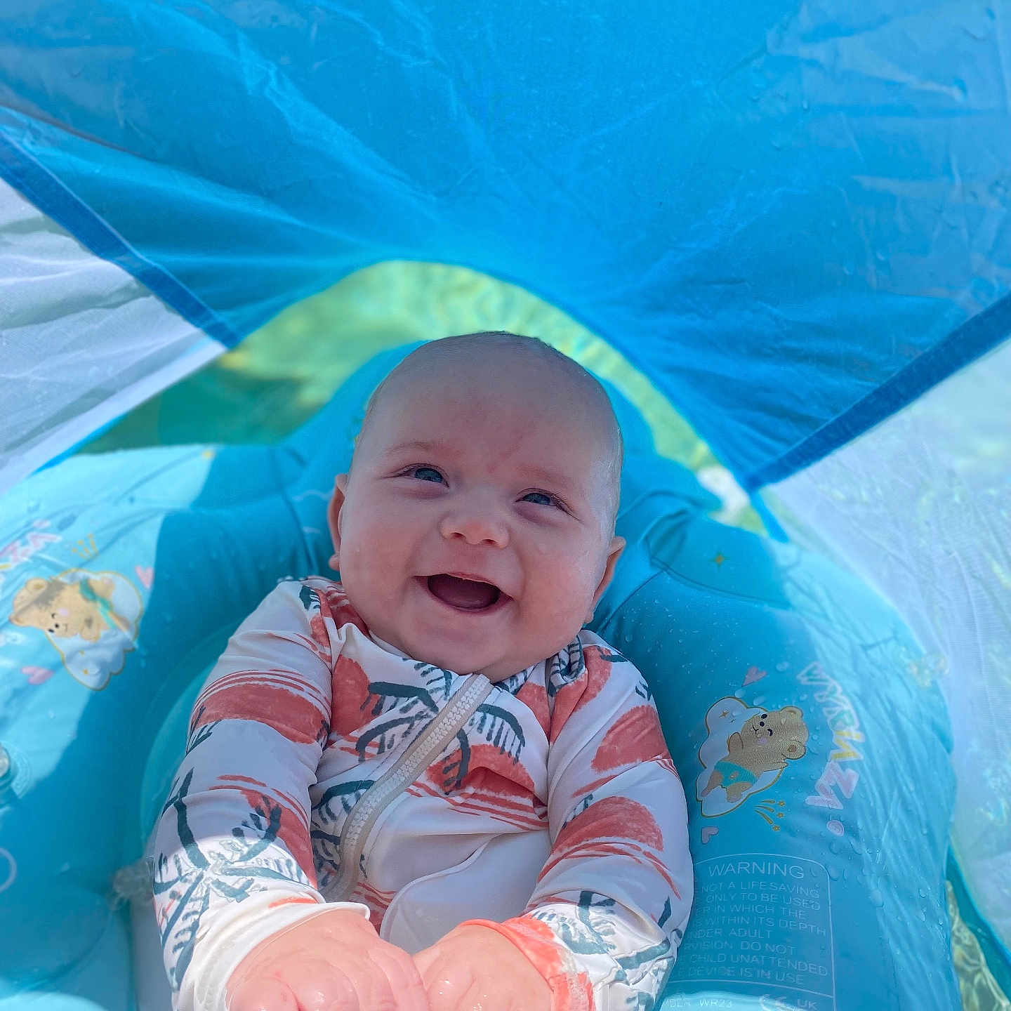 Linkon is registered to the contest to win money with this photo: baby, blue, child, cute, happy, infant, inflatable, joy, outdoor, playful, pool_float, recreation, sitting, smiling, summer, sunlight, sunshade, swimsuit, water, water_toy