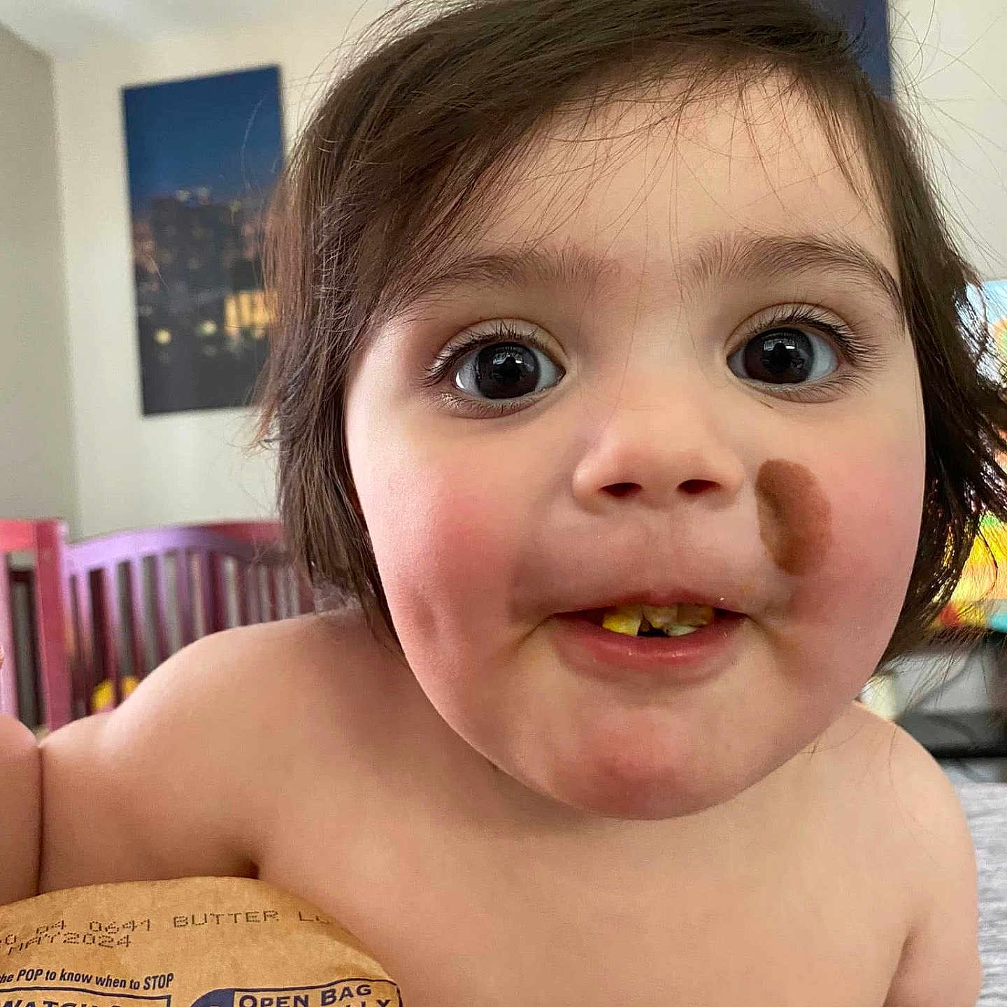 Alicen is registered to the contest to win money with this photo: bag, cheek, child, chocolate, closeup, curly_hair, cute, expression, eyes, face, food, hand, home, indoor, person, popcorn, portrait, smile, snack, toddler