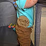 Cayden joined the competition — help win amazing prizes! baby, barefoot, blue_shirt, brown_pants, child, curious, cute, face, head, holding, home, indoor, infant, nine_months, person, playpen, standing, support, tongue_out, young_child