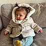 Giulia a rejoint le concours — aidez-le/la à gagner de superbes lots ! baby, child, pigtails, coat, jacket, socks, pants, couch, indoor, cute, face, person, seated, warm_clothing, smiling, cozy, infant, furniture, portrait, young_child