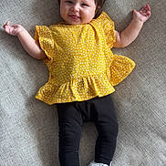 Giulia a rejoint le concours — aidez-le/la à gagner de superbes lots ! baby, smiling, yellow_top, black_leggings, white_sneakers, child, couch, fabric, texture, happy, cute, indoor, person, infant, casual_clothing, footwear, relaxing, portrait, small_child, fashion
