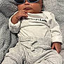 baby, infant, sunglasses, white_shirt, grey_pants, blanket, soft_texture, cute, fashion, portrait, child, casual_wear, relaxed, indoor, cozy, sitting, small_hands, footwear, monochrome_clothing, accessory