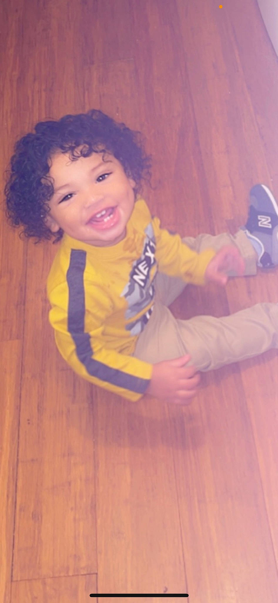 Amontae is registered to the contest to win money with this photo: baby_toddler_clothing, electric_blue, finger, flooring, fun, happy, hardwood, human_leg, joy, laminate_flooring, nose, orange, person, purple, skin, smile, standing, thumb, toddler, varnish