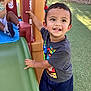 child, toddler, playground, slide, outdoor, smiling, super_mario, tshirt, grass, happy, play, fun, person, daylight, park, young_child, casual_clothing, activity, friends, recreation