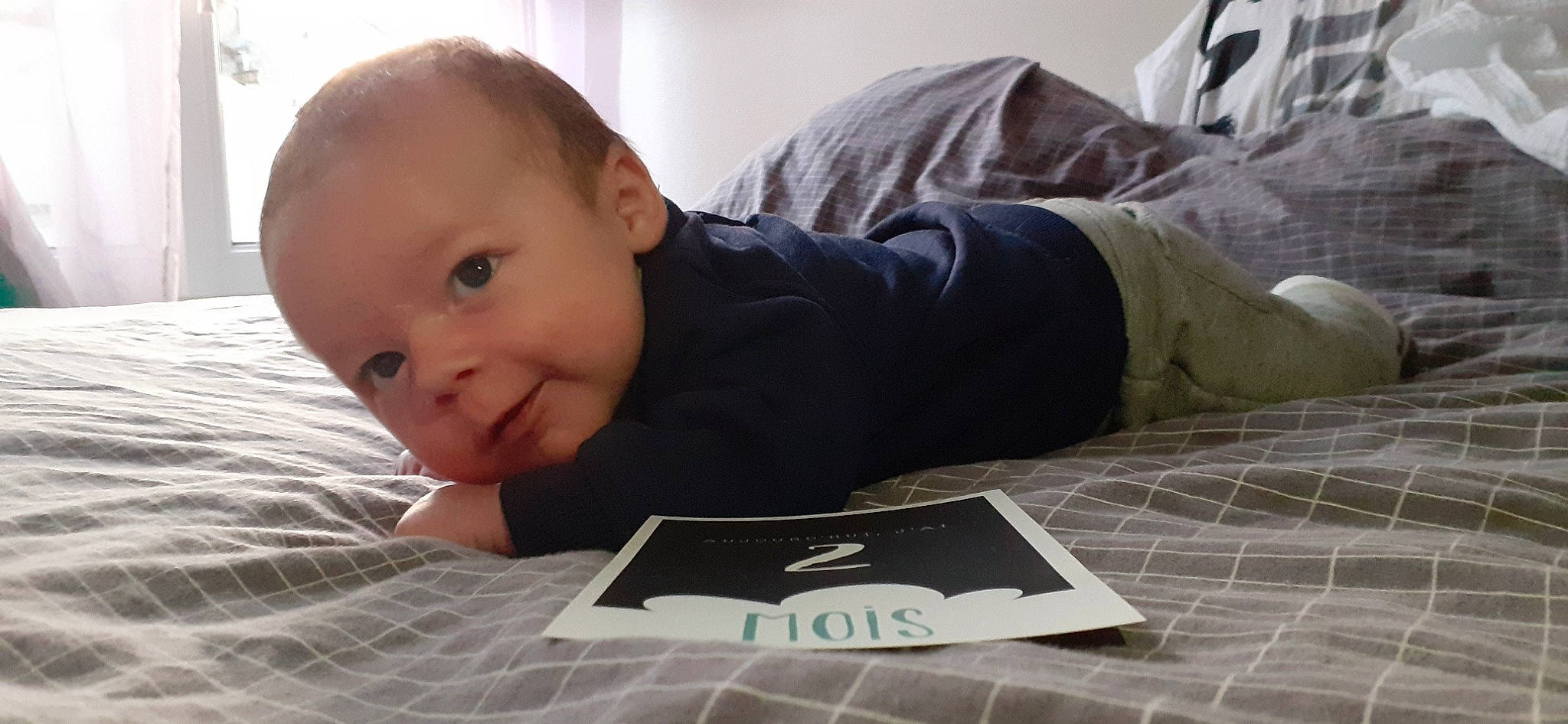 Lény participe au concours pour gagner de l'argent avec cette photo : baby, baby_toddler_clothing, child, comfort, crawling, floor, flooring, font, gadget, happy, hardwood, person, reading, room, sitting, sleeve, smile, toddler, tummy_time, wood