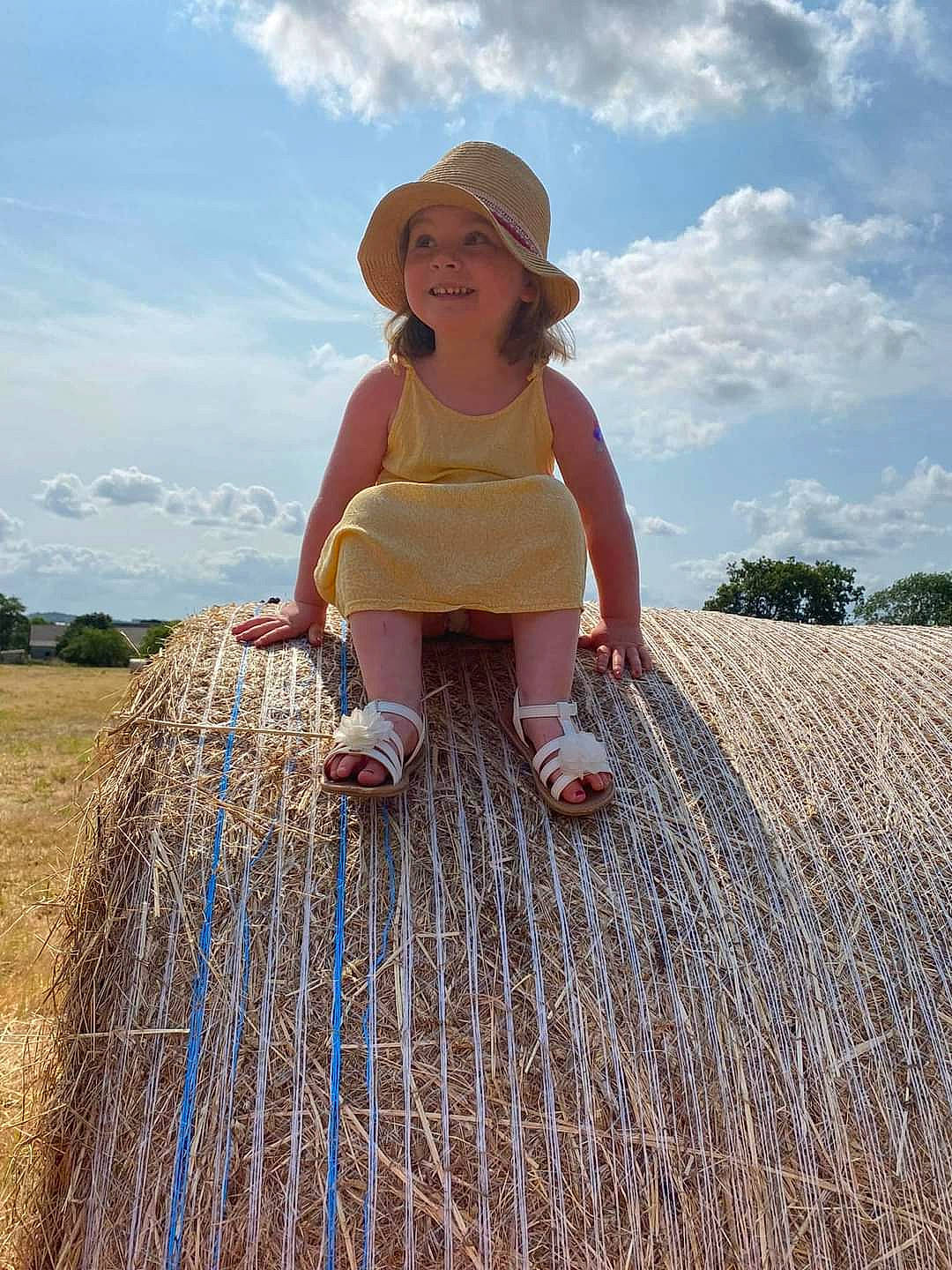 Enora a rejoint le concours — aidez-le/la à gagner de superbes lots ! agriculture, cloud, fedora, field, fun, grass, grassland, happy, hat, hay, headwear, joy, landscape, leisure, meadow, people_in_nature, person, prairie, recreation, sky