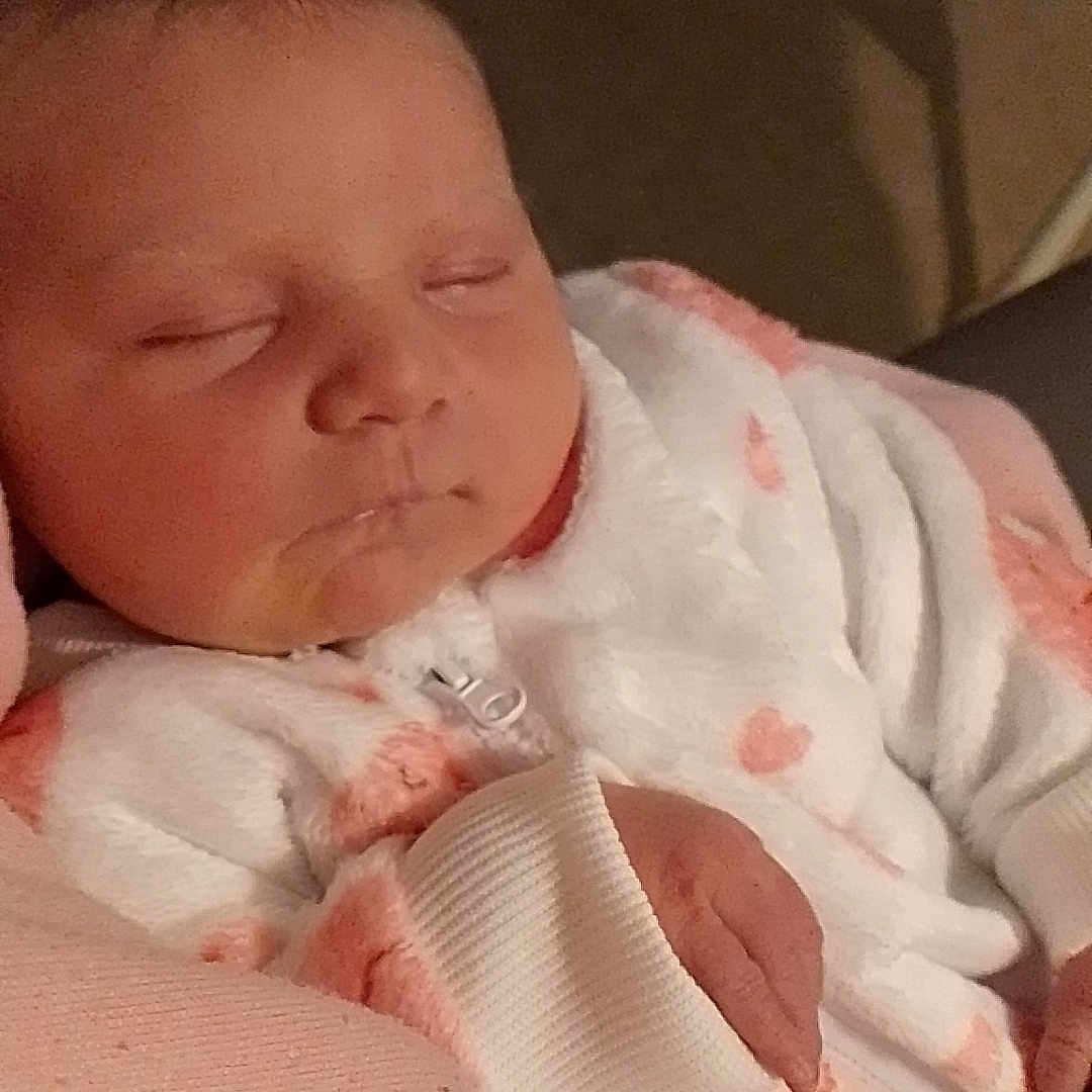 Ava a rejoint le concours — aidez-le/la à gagner de superbes lots ! baby, blanket, cheeks, closeup, clothing, cozy, drool, face, hand, indoor, infant, newborn, nursery_furniture, onesie, parent_lap, peaceful, pink, portrait, sleeping, soft_texture