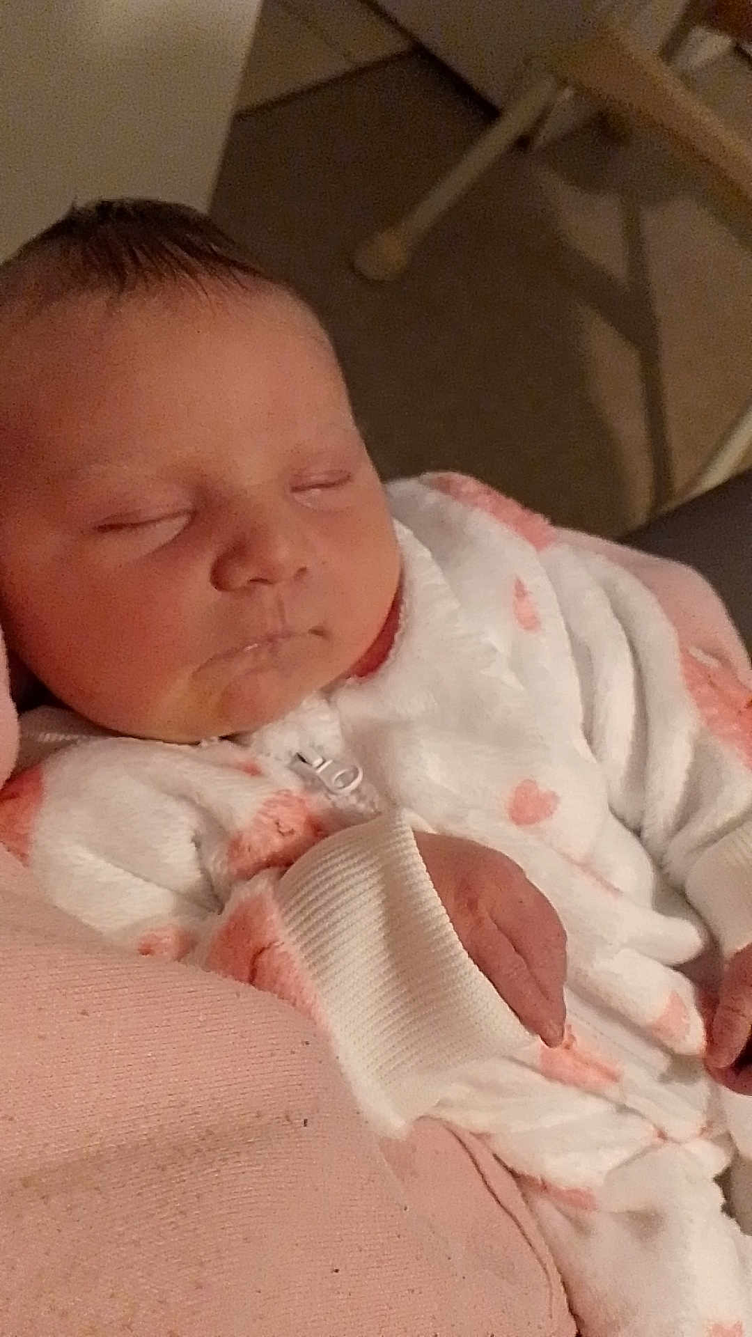 Ava a rejoint le concours — aidez-le/la à gagner de superbes lots ! newborn, baby, sleeping, onesie, pink, blanket, hand, face, cheeks, drool, closeup, portrait, indoor, soft_texture, cozy, parent_lap, infant, clothing, nursery_furniture, peaceful