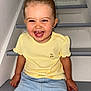blue_jeans, casual_clothing, child, cute, earrings, happy, indoor, joyful, light_skin, person, playful, portrait, short_hair, sitting, smiling, stairs, toddler, top_knot, yellow_shirt, young_child