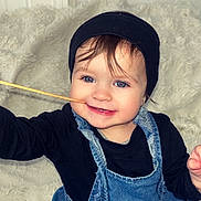 Kaylee a rejoint le concours — aidez-le/la à gagner de superbes lots ! beanie, black_shirt, blue_eyes, child, clothing, cute, denim_dress, face, fun, fuzzy_blanket, happy, indoor, person, playful, portrait, sitting, smiling, toddler, wooden_stick, young_child