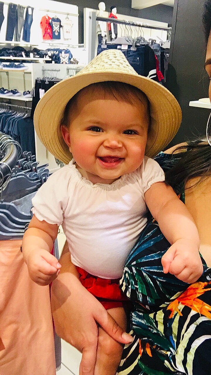 Zina participe au concours pour gagner de l'argent avec cette photo : baby, cheek, child, fashion_accessory, hat, headgear, joy, leg, person, sitting, skin, smile, sun_hat, toddler