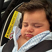 Leon is registered to the contest to win money with this photo: baby, infant, sleeping, car_seat, safety_harness, portrait, face, closed_eyes, peaceful, indoors, vehicle, blanket, blue_clothing, brown_hair, child, passenger, resting, close_up, photography, safe_travel