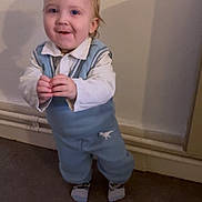 Mayron participe au concours pour gagner de l'argent avec cette photo : toddler, child, indoor, blue_outfit, dinosaur_print, hands, standing, wall, pipes, shadow, floor, socks, cute, happy, person, portrait, young_child, casual_clothing, smile, light