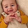baby, blanket, button, candid, child, closeup, cute, eyes, face, fingertips, hands, happy, infant, mustard_shirt, overalls, portrait, skin, smiling, soft_texture, warm_colors