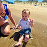 toddler, child, adult, beach, sand, water, sunny, blue_sky, summer, playing, splashing, happy, casual_clothing, vacation, outdoor, family, fun, sand_dune, people, sunlight