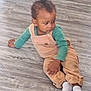baby, casual_clothing, child, curious, cute, feet, floor, green_shirt, hands, home, indoor, looking_sideways, overalls, person, sitting, small_ponytail, socks, toddler, wooden_floor, young_child